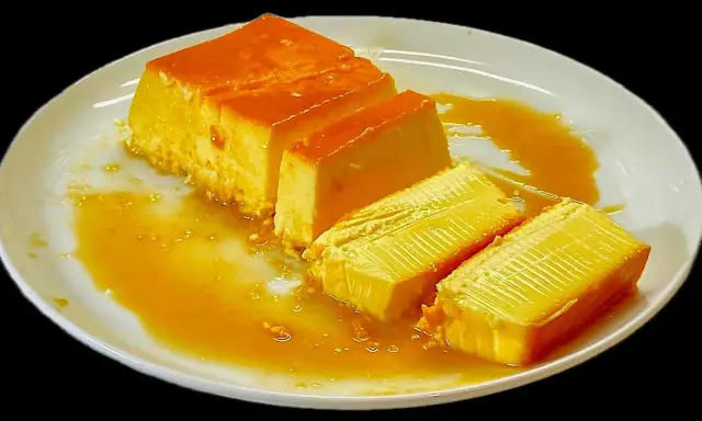 Fette di latte alla portoghese su un piatto bianco, con sciroppo d'oro che cola.
