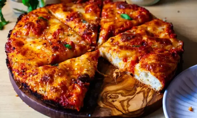 Pyszna pizza rzymska z chrupiącym ciastem, ciągnącym serem i aromatycznym sosem pomidorowym, podana na drewnianej desce.