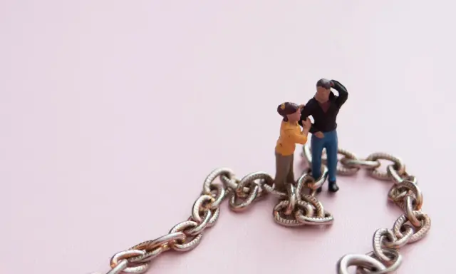 Figuras de pareja unidas por una cadena, simbolizando la codependencia de pareja.