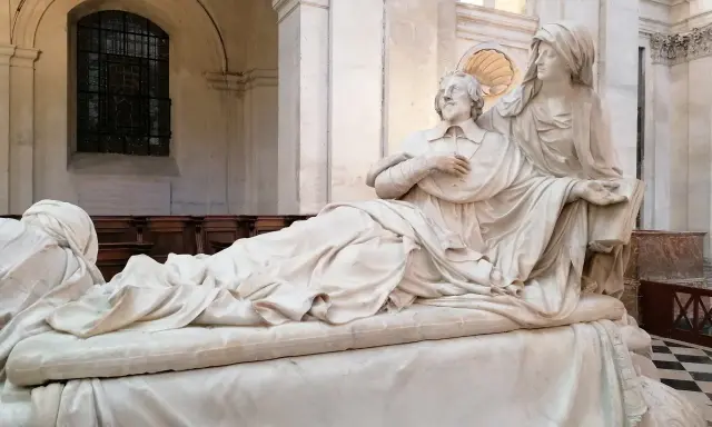 Pomnik kardynała Richelieu. Ciekawostki o jego życiu i wpływach. Rzeźba przedstawia go w otoczeniu alegorycznych postaci.