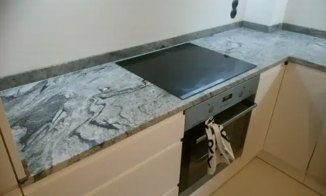 Elegancki blat granitowy 2 czy 3 cm z wbudowaną płytą indukcyjną i piekarnikiem.