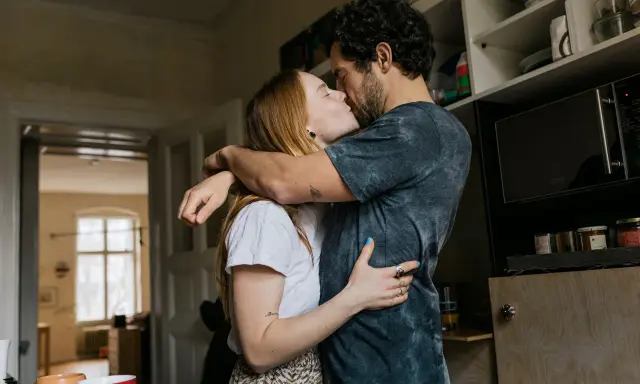 Pareja besándose apasionadamente, sus abrazos y miradas son claras señales no verbales de su amor.