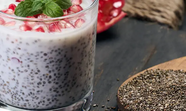 Chia-Samen-Pudding mit Granatapfel und Minze. Bei übermäßigem Verzehr können Chia-Samen Nebenwirkungen haben, auch für die Leber.