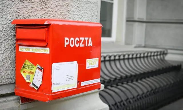 Czerwona skrzynka pocztowa z napisem "POCZTA". Można tu wysłać paczkę za granicę, listy i inne przesyłki.