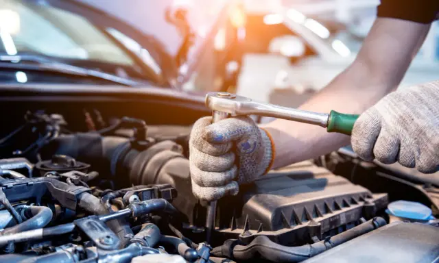 Mecánico revisa el motor de un coche. Aprende como saber si un motor esta quemado observando los componentes.