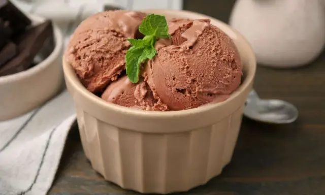 Schokoladeneis, frisch zubereitet, in einer Schale mit Minze garniert. Perfekt, um eis selber machen zu lernen.
