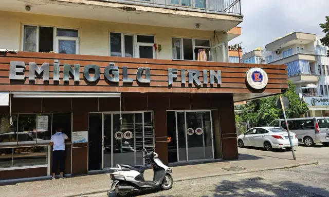 Przed piekarnią "Eminoglu Firin" z napisem "cześć po turecku" stoi skuter.
