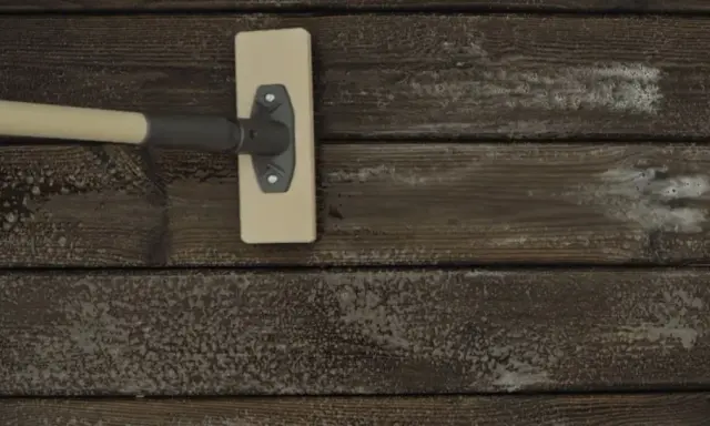 En borste med skum rengör träet. Snart är det dags att skura altan för sommaren.