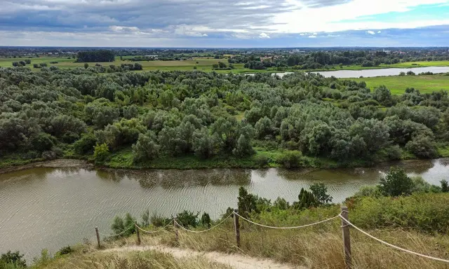 Malownicza trasa przez Góry Pieprzowe. Rzeka, lasy i pola rozciągają się pod pochmurnym niebem.