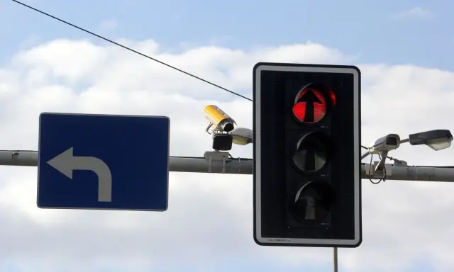 Fotoradar na światłach, czerwone światło dla kierunku na wprost. Obok znak nakazu skrętu w lewo.