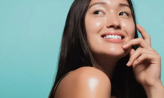 Donna sorridente con pelle luminosa e idratata, un esempio di come idratare la pelle senza creme.
