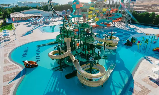Kolorowy aquapark Fantazia Resort Marsa Alam z licznymi zjeżdżalniami i basenami, w tym z motywem statku pirackiego.