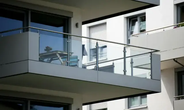 Nowoczesna loggia z przeszkloną balustradą, stolikiem i krzesłem. Idealne miejsce na poranną kawę.