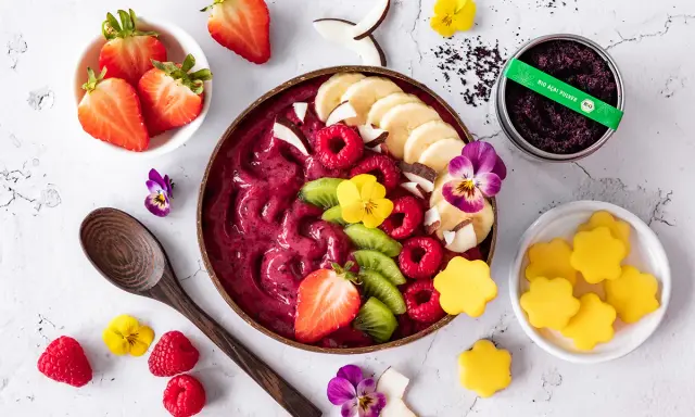 Ein farbenfrohes Acai Bowl Rezept mit frischen Beeren, Bananen, Kiwi, Kokos und essbaren Blüten. Perfekt für einen gesunden Start!
