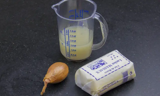 Ingrédients pour un beurre blanc : un oignon, un pichet gradué avec du liquide, et un beau morceau de beurre Lucien Massaux.