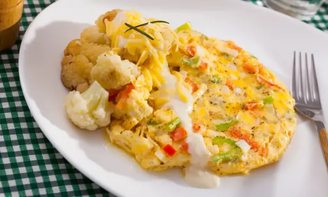 Pyszny omlet z warzywami i serem, podany z kalafiorem. Świetny pomysł, co zrobić z białek, gdy masz ochotę na coś lekkiego i sycącego.