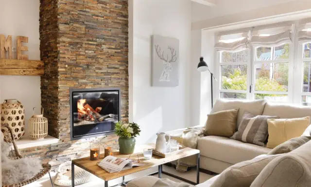 Acogedor salón moderno con chimenea de leña, sofá beige y mesa de centro de madera.