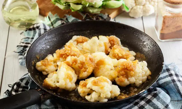 Cavolfiore in padella, dorato e saporito, pronto per essere gustato.