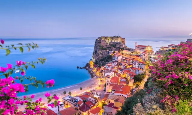Scilla, Calabria: un borgo da sogno dove andare al mare, con il castello Ruffo a picco sul blu e fiori colorati.