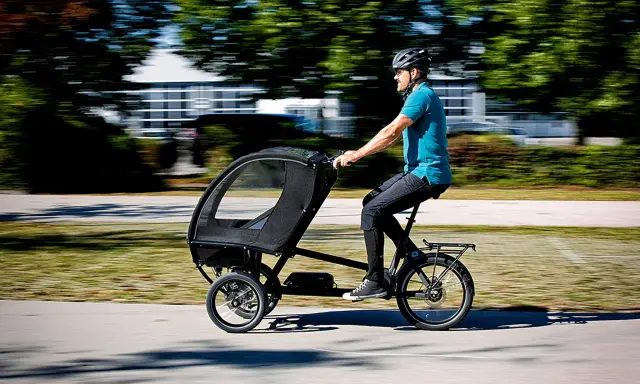 Mann fährt ein Lastenrad mit Kabine, ideal für lastenrad erwachsene transportieren.