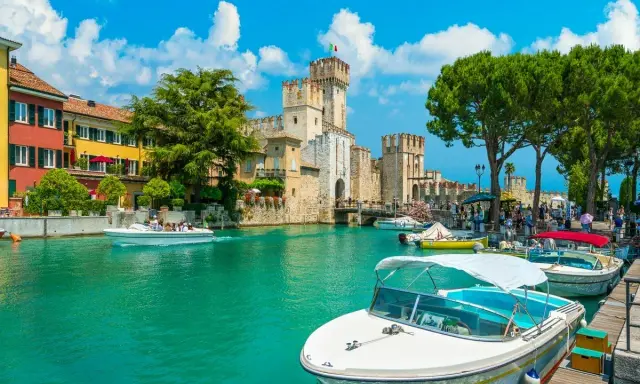 Malowniczy rejs po Jeziorze Garda. Woda lśni, a zamek Scaligero w Sirmione zaprasza do zwiedzania.
