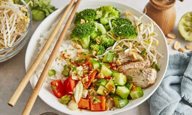 Ein bunter Asia Bowl mit Reis, Hähnchen, Brokkoli, Gurken, Tomaten und Sojasprossen. Perfekt für ein leichtes Mittagessen.