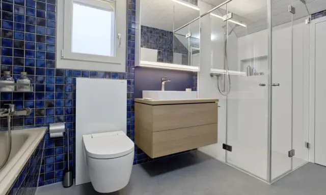 Modernt badrum med blå mosaik, flytande kommod och duschkabin. Perfekt badrum inspiration för ett stilrent hem.