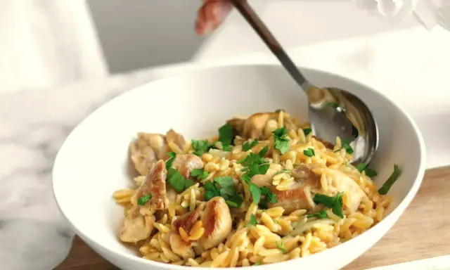 Szybki obiad z makaronem orzo i kurczakiem, posypany natką pietruszki. Idealny na szybki posiłek.