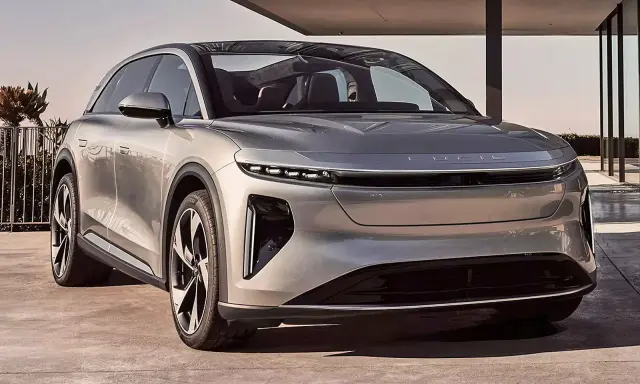 Silberner Lucid Air, der die **lucid gravity** des Designs verkörpert, steht vor einem modernen Gebäude.