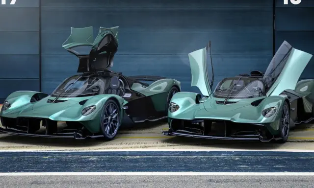 Zwei Aston Martin Valkyrie Spider in Mintgrün mit geöffneten Flügeltüren stehen nebeneinander.