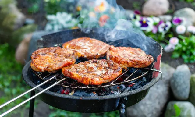 Saftige Steaks brutzeln auf dem Grill. Das Aroma von gegrilltem Fleisch liegt in der Luft.