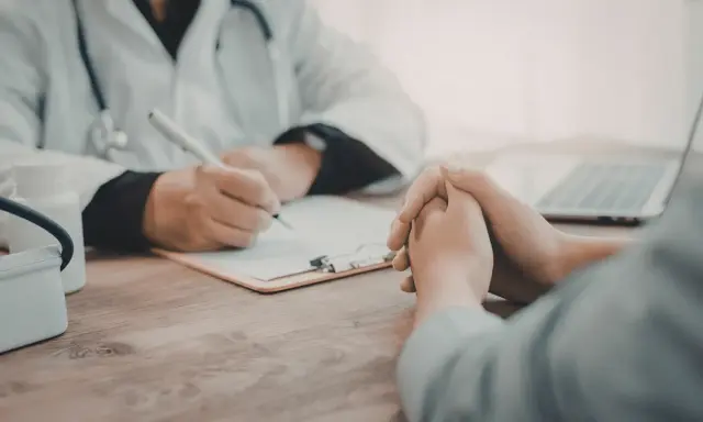 Consultation médicale : un médecin note des informations sur une liste maladie professionnelle secrétaire.