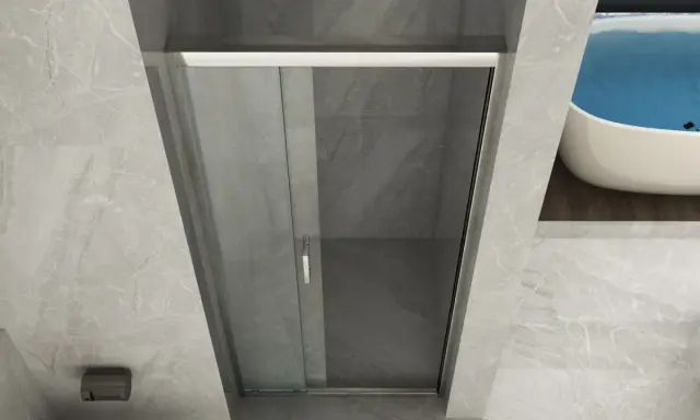 Doccia angolare con porta scorrevole in vetro. La nicchia doccia è rivestita in marmo grigio, con una vasca da bagno sullo sfondo.