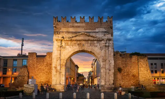Arco d'Augusto a Rimini al tramonto, con il suo skyline suggestivo e le nuvole drammatiche.