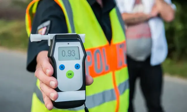 Policjant pokazuje alkomat z wynikiem 0.93 promila. Kontrola trzeźwości to ważny element bezpieczeństwa na drogach.