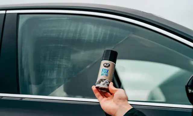 Dłoń trzyma puszkę preparatu K2 FOX ANTI-FOG, który zapobiega zaparowaniu szyb w aucie.