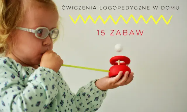 Dziecko w okularach dmucha przez słomkę na drewnianą zabawkę z kulką.