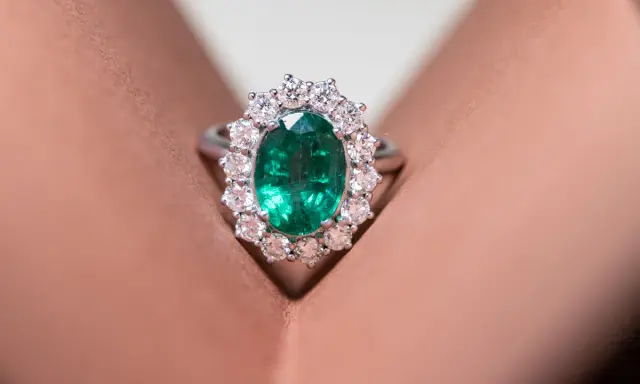 Anello con smeraldo ovale circondato da diamanti, un gioiello di grande valore, più prezioso di un rubino.