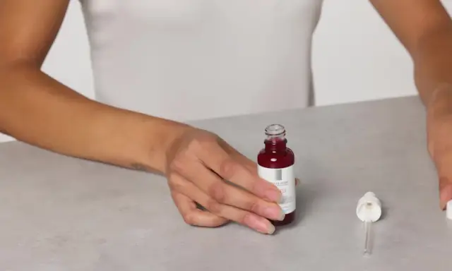 Mani che mostrano il siero Retinol B3 La Roche Posay, pronto per l'uso. Scopri come applicarlo per una pelle radiosa.