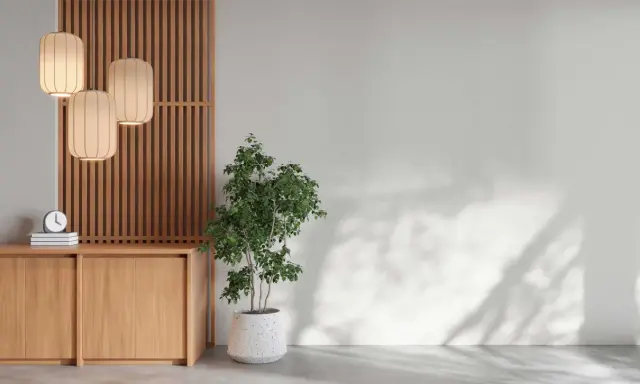 En lugn hörna med en träskärm, tre lampor, en byrå och en grön växt. En perfekt plats för feng shui inredning.
