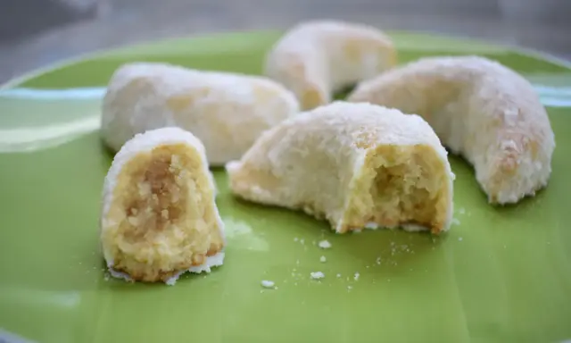 Délicieux biscuits en forme de croissant, saupoudrés de sucre glace, parfaits pour accompagner une tasse de thé. Une recette de corne de gazelle à essayer !