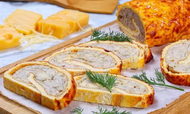 Pyszna rolada serowa z kurczakiem, pokrojona w plastry, z dodatkiem sera i koperku.