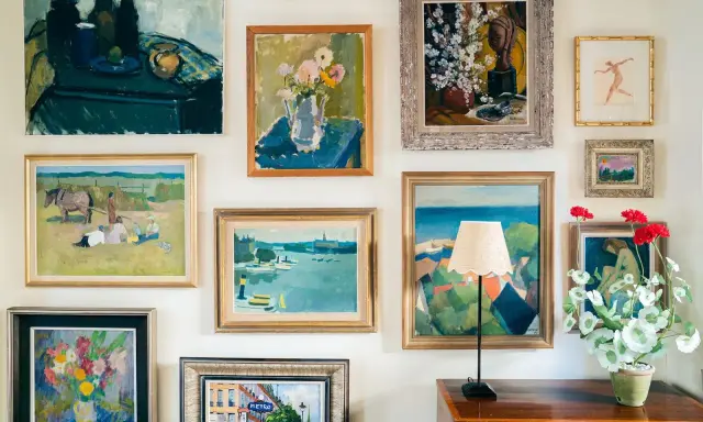 A gallery wall showcasing a diverse collection of paintings, proving that collecting art on a budget can create a vibrant and personal space.