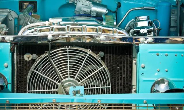 Motor de coche azul brillante con ventilador grande. ¿Por qué no salta el ventilador del coche? Quizás necesite un ajuste.