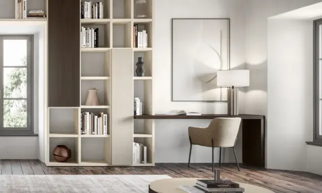 Angolo studio in soggiorno ricavato da libreria componibile. Scrivania integrata, sedia, lampada e quadro astratto.