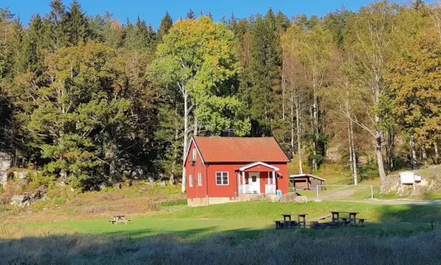 Rött hus i Svartedalen, perfekt för en vandring. Höstfärger i skogen och en solig äng.