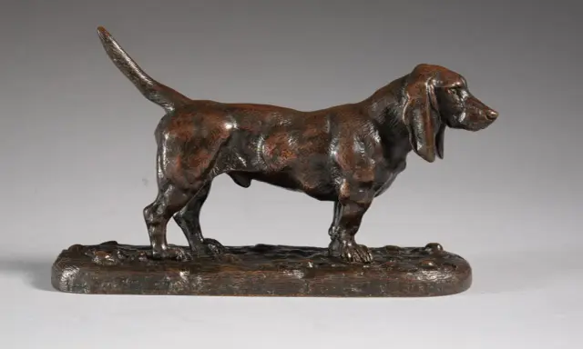 Une sculpture en bronze d'un chien basset hound, une des œuvres d'art de Antoine-Louis Barye, sur un socle imitant le sol.