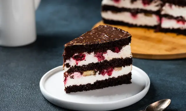 Kawałek czekoladowego tortu z kremem mascarpone, malinami i bananem. Idealny, bardzo łatwy tort z mascarpone na deser.