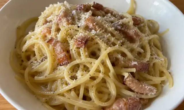 En krämig portion pasta carbonara med knapriga bitar av fläsk och rikligt med svartpeppar.