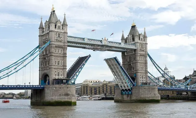 Torre de Londres con sus **puentes levadizos** abiertos, permitiendo el paso de barcos por el río Támesis.
